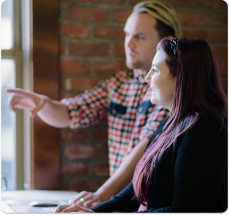 Built Mighty employees, one man and one woman, discussing web design solutions 